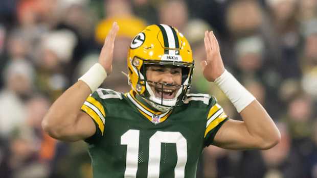 Green Bay Packers quarterback Jordan Love gestures while making a call at the line.